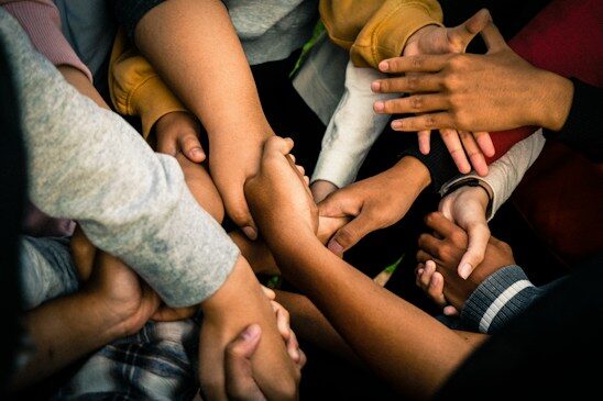 Volunteers joining hands in a circle