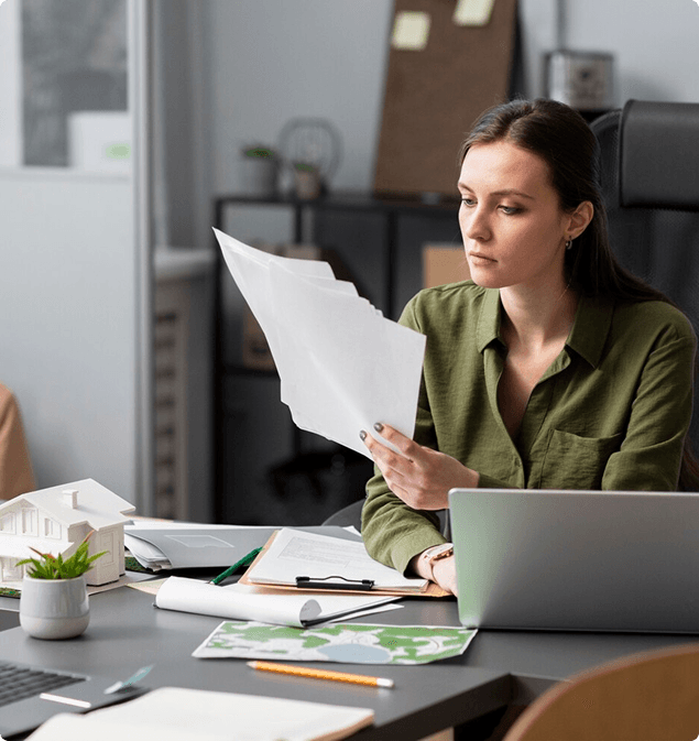 Payroll specialist reviewing printed documents at her desk