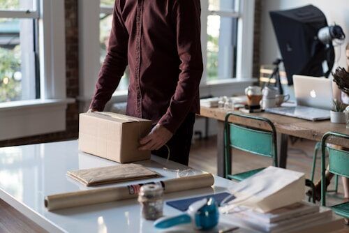 Online seller packing orders at a desk