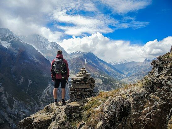 Hiker looking out over snow-capped mountains