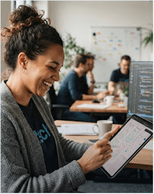 Finance professional smiling while working on a tablet