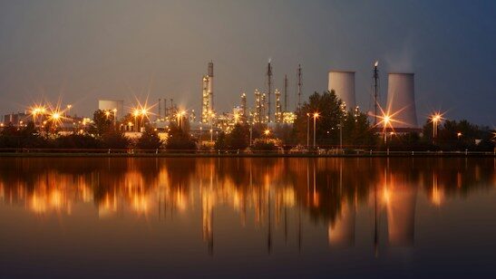 Power plant lit up at night over water