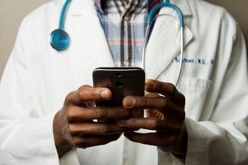 Doctor with a stethoscope checking a phone