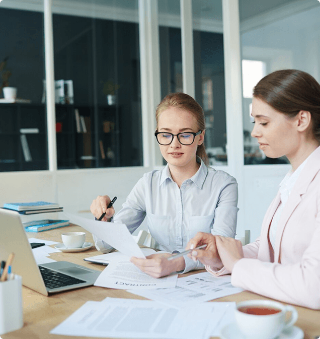 Two professionals reviewing documents together at an office desk