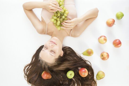 Woman lying among fresh fruit