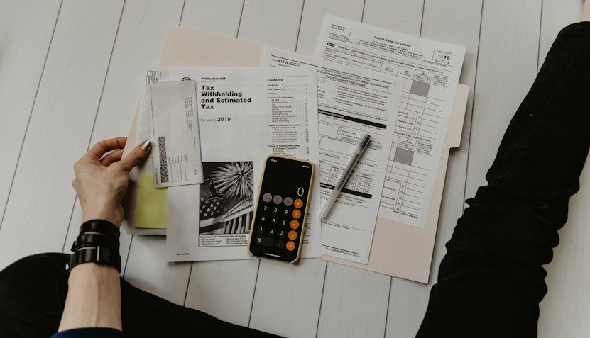 Tax forms and a calculator on a desk